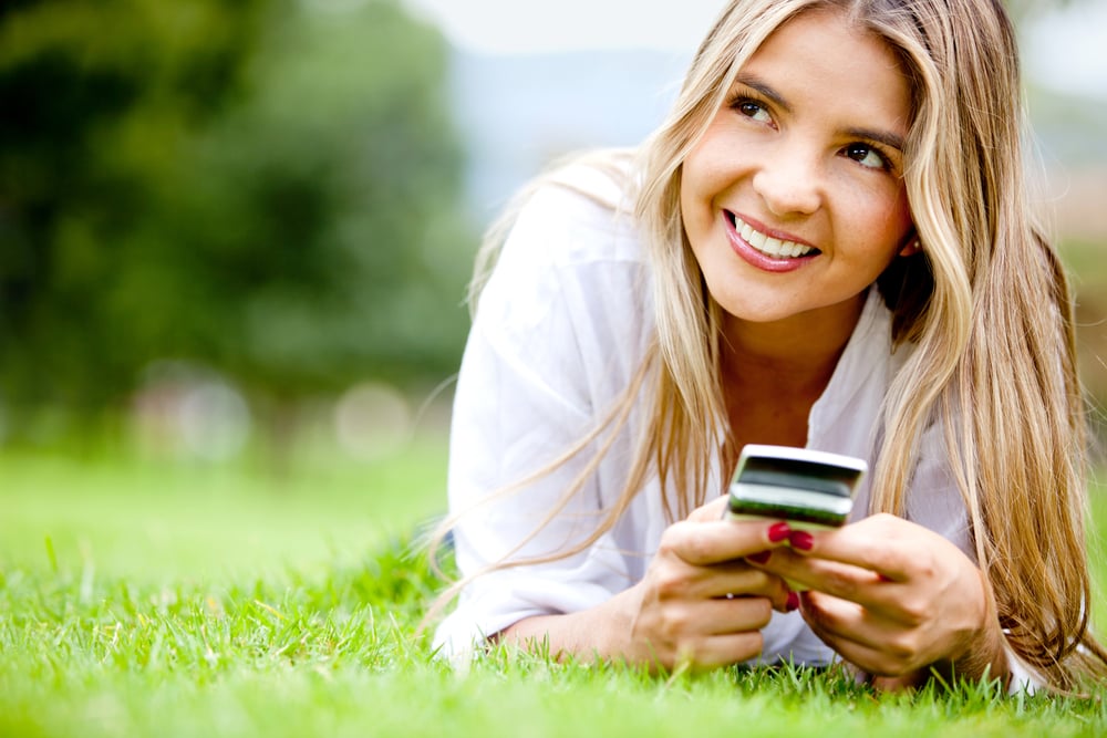Woman outdoors texting on her mobile phone